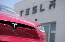 A Tesla model X sports-utility vehicle sits outside a Tesla store. 