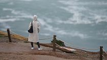 Egy nő a Portugália Nazare községében megtalálható Praia do Nortén (azaz Északi Strandon) nézi a tengert egy szikla tetejéről. (AP Photo/Armando Franca)