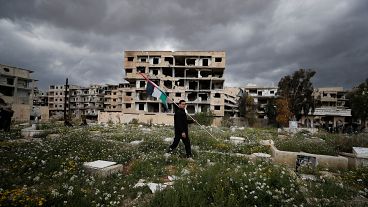Suriye'nin başkenti Şam'daki Yermuk mülteci kampında bir adam Filistin bayrağı taşıyor.