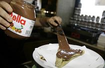 A bartender in Rome spreads Nutella on a crepe