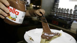 Un camarero de Roma unta Nutella en un crepe