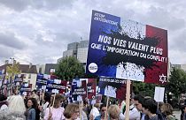 People gather against anti semitism, one carrying a placard reading "our lives worth more that an imported conflict" Thursday, June 20, 2024 in Paris. The alleged rape of a 12