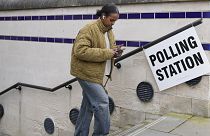 Bir kadın Londra'da oy kullandıktan sonra seçim merkezinden ayrılıyor