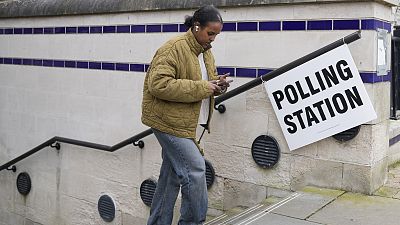 A woman leaves a polling station after voting in London