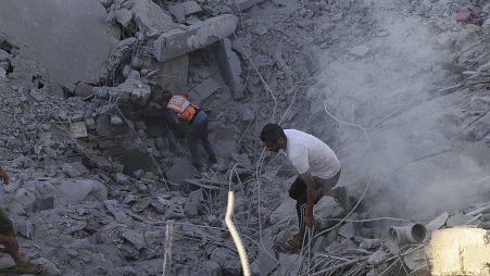 Palestinesi cercano corpi e sopravvissuti tra le macerie di un edificio residenziale distrutto da un attacco aereo israeliano a Khan Younis (3 luglio 2024)