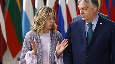 Hungary's Prime Minister Viktor Orban, right, speaks with Italy's Prime Minister Giorgia Meloni prior to a group photo at an EU summit in Brussels, Thursday, June 27, 2024.