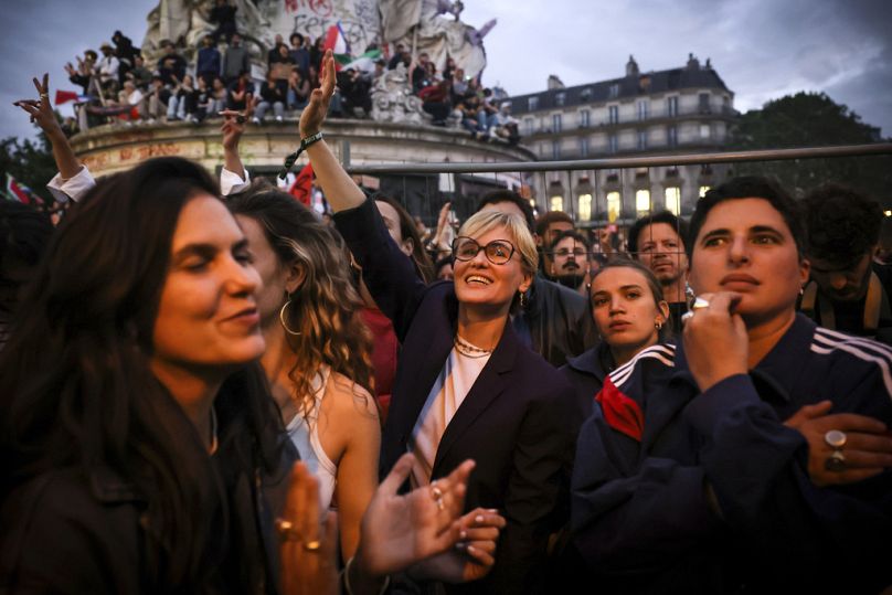 Actress Judith Godrèche, center, waves during a gathering at Republique plaza in a protest against the far-right, Wednesday, July 3, 2024 in Paris.