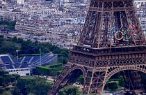 The Olympic rings on the Eiffel Tower in Paris, France. The Champ-de-Mars at left will host the Beach Volleyball and Blind Football at the Paralympic Games.