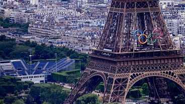 Los anillos olímpicos en la Torre Eiffel de París, Francia. El Campo de Marte, a la izquierda, acogerá el voley playa y el fútbol para ciegos en los Juegos Paralímpicos.