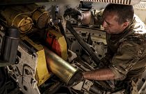 um militar prepara-se para disparar um obuseiro "Gvozdika" de fabrico soviético de 120 mm contra posições russas nos arredores de Chasiv Yar, 22 de junho de 2024