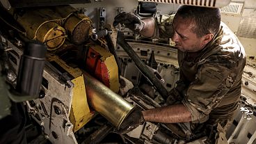 um militar prepara-se para disparar um obuseiro "Gvozdika" de fabrico soviético de 120 mm contra posições russas nos arredores de Chasiv Yar, 22 de junho de 2024