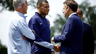  French President Emmanuel Macron, right, shakes hands with Kylian Mbappe next to head coach Didier Deschamps in Paris, June 3 2024