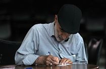 An Iranian man fills out his ballot for the presidential runoff election at a polling station in Tehran, 5 July 2024