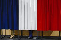 Fransa Cumhurbaşkanı Emmanuel Macron ve eşi Brigitte Macron, 30 Haziran 2024 Pazar günü Fransa'nın kuzeyindeki Le Touquet-Paris-Plage'de oy kullanmadan önce oy kabininde duruyor. (Yara 