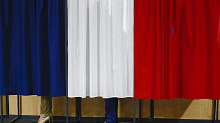 O Presidente francês Emmanuel Macron e a sua mulher Brigitte Macron estão na cabina de voto antes da votação em Le Touquet-Paris-Plage, no norte de França, no domingo, 30 de junho de 2024. (Yara 