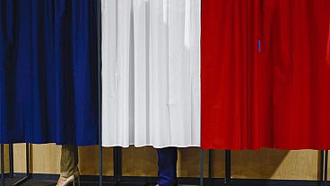 Il presidente francese Emmanuel Macron e sua moglie Brigitte Macron in piedi nella cabina elettorale prima di votare a Le Touquet-Paris-Plage, nel nord della Francia, domenica 30 giugno 2024. (Yara 