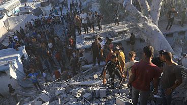 فلسطينيون يبحثون عن جثث وناجين بين أنقاض مبنى سكني دمره قصف إسرائيلي في خان يونس بقطاع غزة، الأربعاء 3 يوليو/تموز 2024.