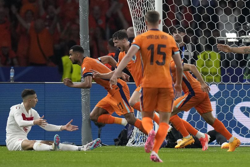 O holandês Cody Gakpo, segundo à esquerda, festeja com os colegas de equipa após o segundo golo da sua equipa durante um jogo dos quartos de final entre a Holanda e a Turquia 