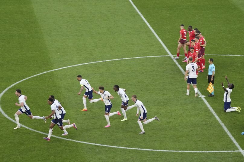 Jogadores ingleses correm em direção a Trent Alexander-Arnold após a vitória por penálti contra a Suíça