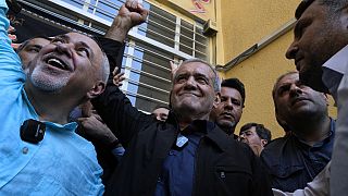 Reformist candidate for the Iran's presidential election Masoud Pezeshkian clenches his fist after casting his vote.