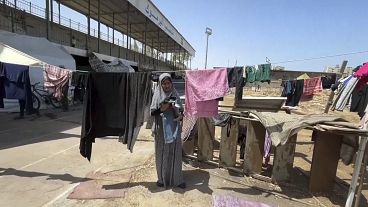 Gazze'de bir kadın savaş nedeniyle sığındığı Yarmuk Stadyumu'nda kıyafetleri kuruluyor, 6 Temmuz 2024
