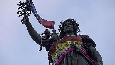 Statue of Republique plaza is decorated by flags as people gather at a protest against the far-right, Wednesday, July 3, 2024 in Paris. 