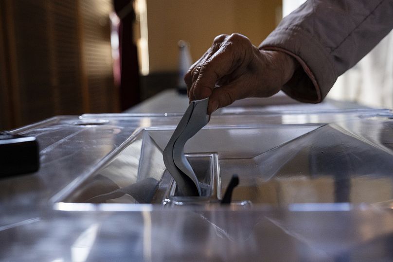 A voter casts a ballot at a polling station for the first round of the parliamentary elections in Paris, June 30, 2024