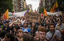 Rund 500 Einwohner Barcelonas protestieren gegen den Massentourismus während einer Ausstellung von Formel-1-Rennwagen in der spanischen Stadt.