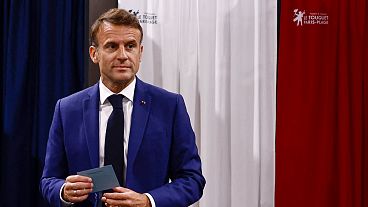 FILE - French President Emmanuel Macron leaves the voting booth before voting in the early French parliamentary election.
