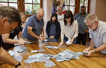 Assistentes de voto contam os boletins de voto numa assembleia de voto em Soultz-Les-Bains, no leste de França, domingo, 30 de junho de 2024