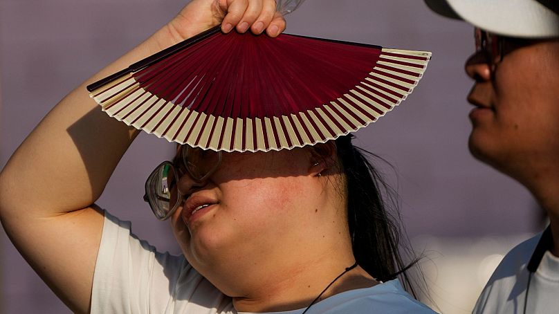 Çin'de bir kadın artan sıcaklardan dolayı yelpaze kullanıyor, Beijing, Çin, 16 Haziran, 2024. (Fotoğraf: AP)