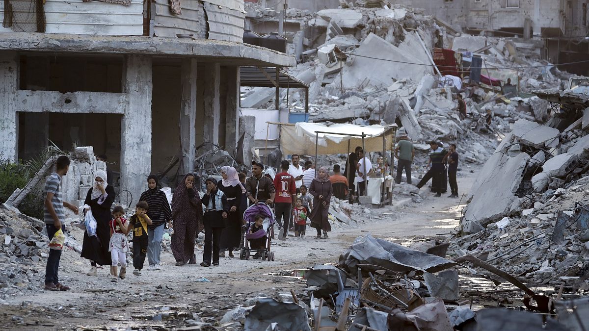 فلسطينيون نازحون بسبب الهجوم الجوي والبري الإسرائيلي على قطاع غزة يسيرون بجانب مياه الصرف الصحي المتدفقة في شوارع مدينة خان يونس الجنوبية، قطاع غزة، 4 يوليو 2024