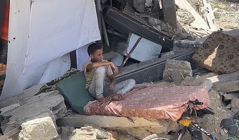 طفل فلسطيني يجلس على أنقاض الدمار في ستاد ملعب اليرموك في غزة