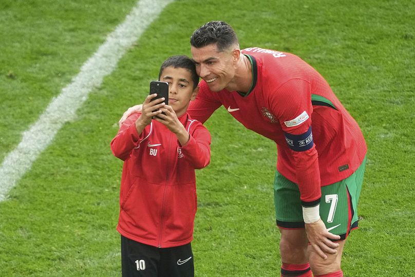 Un joven invasor del campo se toma una selfie con el portugués Cristiano Ronaldo durante un partido entre Turquía y Portugal en Alemania, el 22 de junio de 2024.