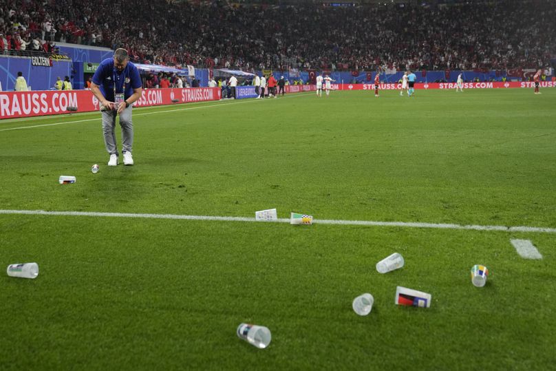 Plastikbecher, die von österreichischen Fans geworfen wurden, liegen auf dem Spielfeld,  am Dienstag, 2. Juli 2024.