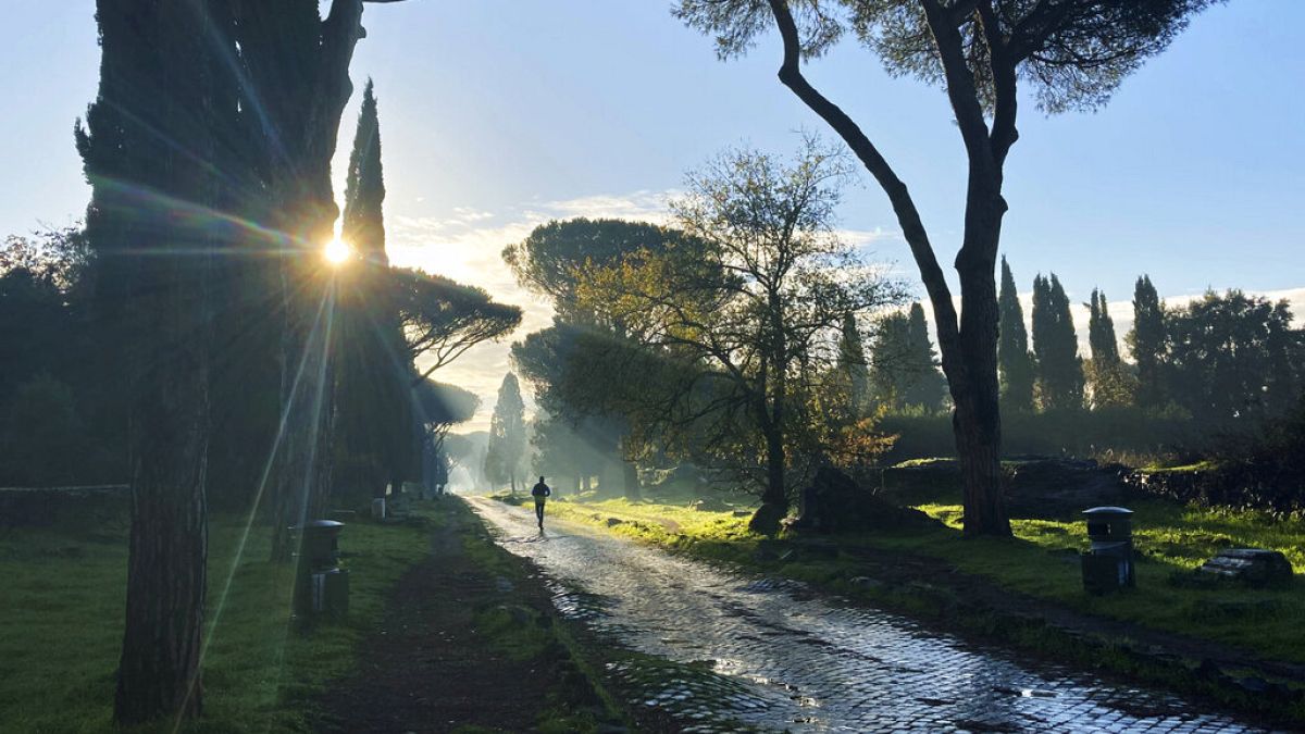 A man jogs on the ancient roman Appian Way in Rome