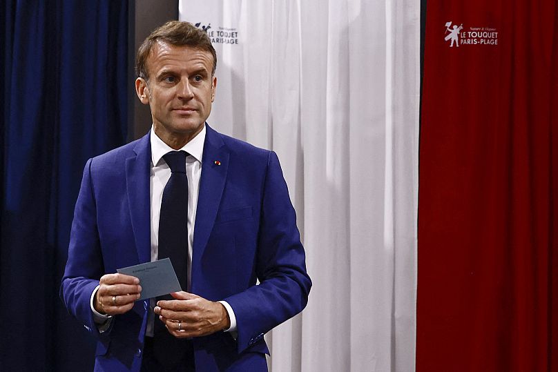 French President Emmanuel Macron leaves the voting booth before voting in the early French parliamentary election.