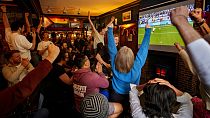 Pessoas festejam no pub Old Justice, em Londres, durante a disputa de pénaltis do jogo dos quartos de final entre a Inglaterra e a Suíça no Euro 2024, na Alemanha.