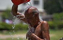رجل يحاول تخفيض حرارة جسمه خلال يوم صيفي حار في حديقة في كراتشي، باكستان، الثلاثاء 21 مايو/أيار 2024. 