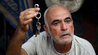 حسن نوفل، 53 عامًا، نزح بسبب القصف الإسرائيلي على قطاع غزة، يحمل مفاتيح منزله الذي أُجبر على مغادرته مع عائلته في مخيم مؤقت في خان يونس، جنوب قطاع غزة تموز 2024