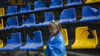 Ein junges Mädchen steht vor den zerstörten Sitzen des Sonyachny-Stadions in Charkiw, das für die Euro 2012 gebaut wurde.