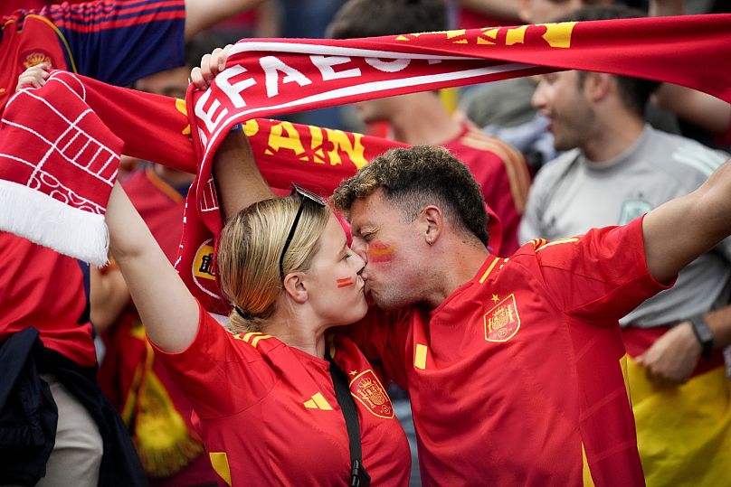 Dos aficionados españoles se besan durante un partido de España. Berlín, Alemania.