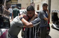 Palesztinok gyászolják a Gázai övezet izraeli bombázása során meghalt hozzátartozóikat a deir al-Balahi kórház hullaházában.
