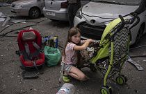 Polina, 10, kümmert sich um ihre Schwester Marina, 3, auf dem Gelände des Kinderkrankenhauses von Okhmatdyt, das von russischen Raketen getroffen wurde, in Kiew, Ukraine, Montag, 8. Juli 2024 (AP Photo/Alex Baben