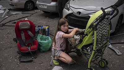 Polina, 10 ans, s'occupe de sa sœur Marina, 3 ans, sur le site de l'hôpital pour enfants Okhmatdyt touché par des missiles russes, à Kiev, en Ukraine, le lundi 8 juillet 2024 (AP Photo/Alex Baben).