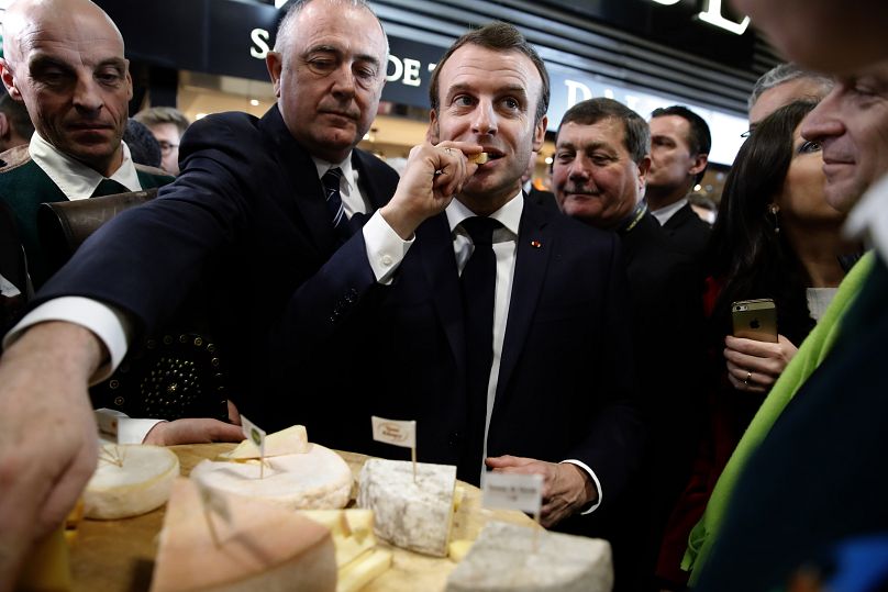 Il presidente francese Emmanuel Macron mangia del formaggio alla Fiera Internazionale dell'Agricoltura a Parigi (22 febbraio 2020)