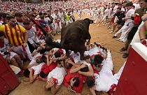A cow jumps over a group of revellers laid on the ground of the bullring during the fourth day of the running of the bulls at the San Fermín fiestas in Pamplona.