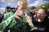 A man smokes as people celebrate at the Brandenburg Gate during a rally and festival to legalise cannabis, in Berlin in April
