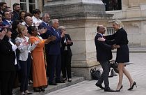 French far-right leader Marine Le Pen, right, arrives to pose with newly elected parliament members of the National Rally party at the National Assembly Wednesday, July 10, 20