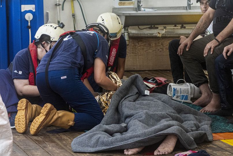  متطوعي منظمة SOS Mediterranee وهم يساعدون المهاجرين الذين تم إنقاذهم من قارب خشبي على متن سفينة إنقاذ خاصة بهم في البحر الأبيض المتوسط، الثلاثاء 9 يوليو 2024. 